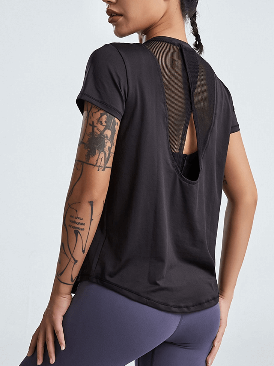 Woman wearing a short-sleeved yoga t-shirt with breathable mesh back, perfect for running or yoga workouts.